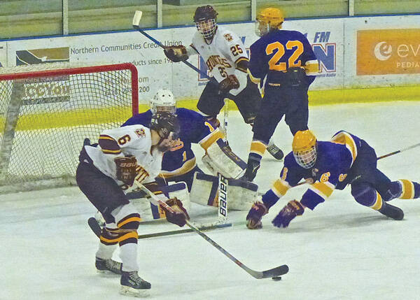 Denfeld’s Jacob Marciniak tried to shoot a backhand before International Falls’ Riley Nemec could dive in the way. Photo credit: John Gilbert