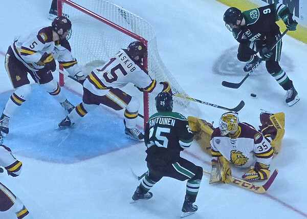 UMD goalie Hunter Miska was down and out, but defensemen Nick Wolff (5) and Willie Raskob hustled to the crease to cover. Photo credit: John Gilbert