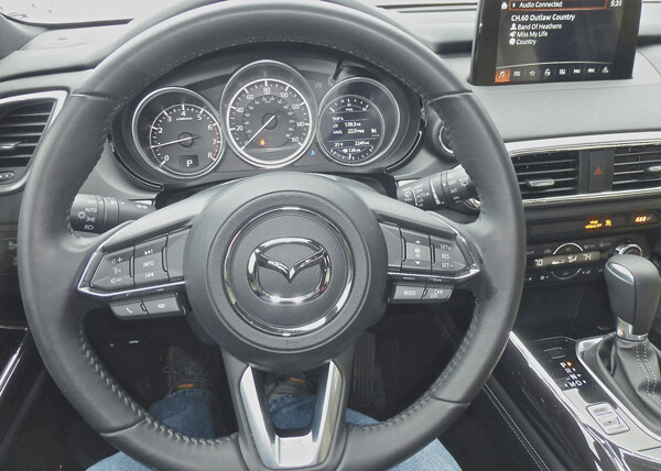 Driver’s eye view of steering wheel with its remote switches and instrumentation. Photo credit: John Gilbert