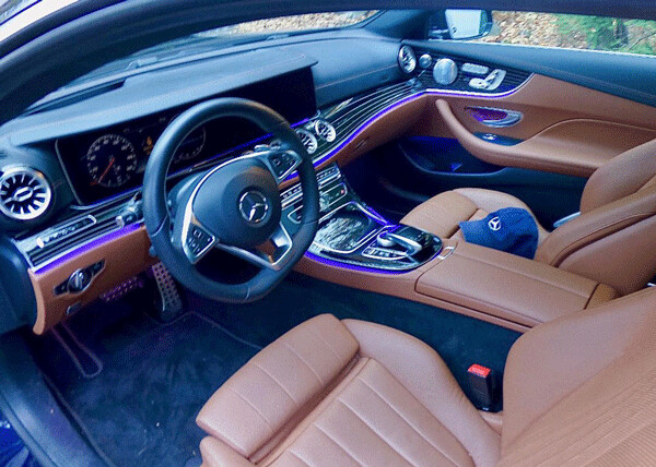The E400 Coupe interior is rich leather and real wood, and notice the neat blue LED stream of ambient light surrounding occupants. Photo credit: John Gilbert