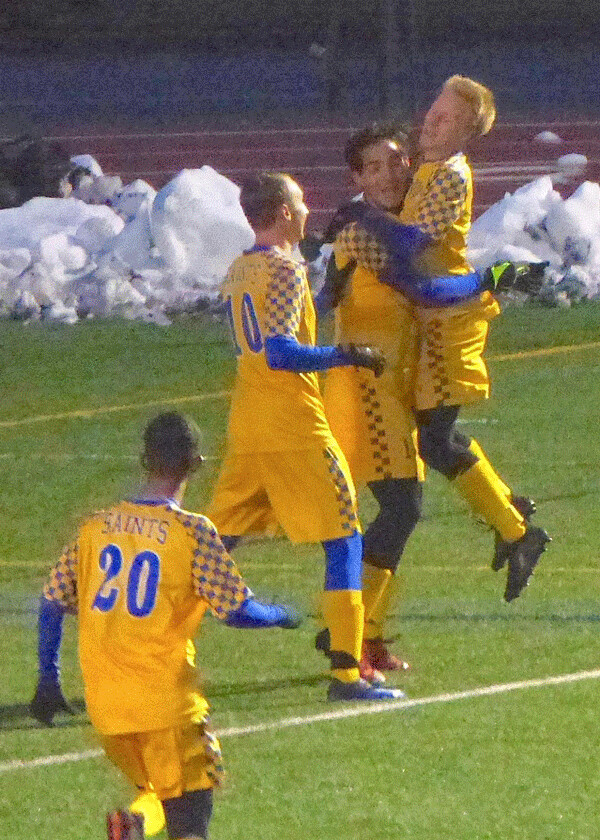 St. Scholastica's Juan Ochoa, right, was hoisted off the ground after his goal gave the Saints a 1-0 lead in the UMAC playoff final Saturday, but UWS came back to win the title 2-1 on a penalty kick shootout. Photo credit: John Gilbert