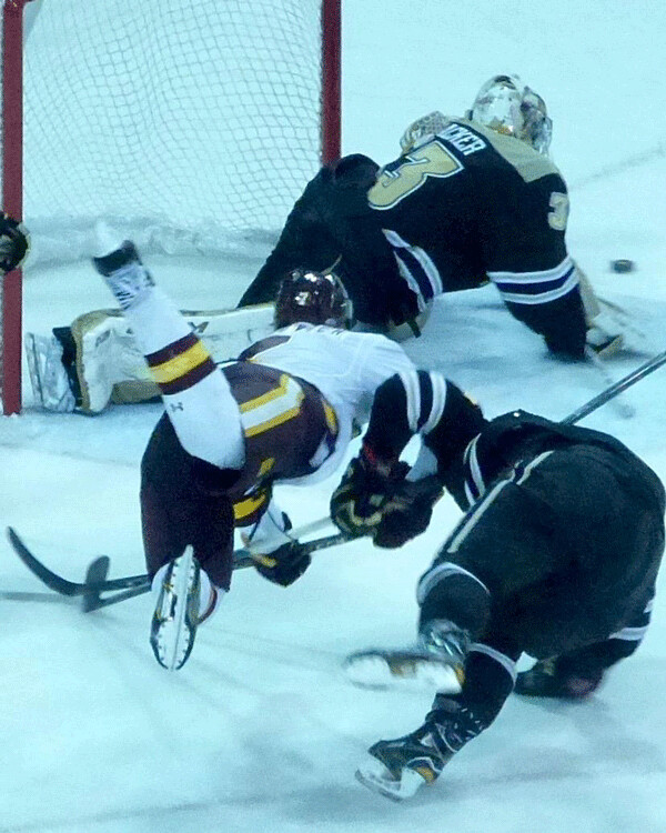 UMD freshman defenseman Scott Perunovich rushed in to make a pass and went hurtling after it before an unscheduled landing. Photo credit: John Gilbert