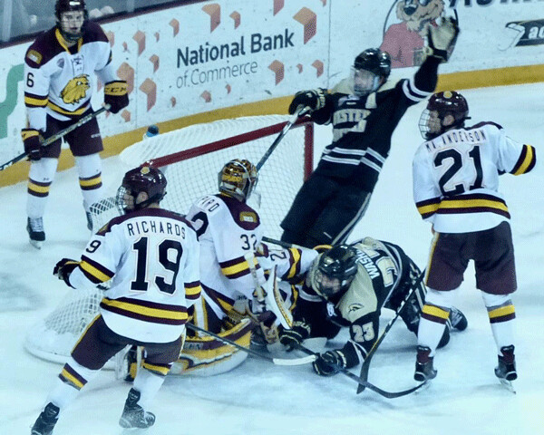 In Saturday's reversal, the Broncos stormed Hunter Shepard's goal, and after a review, a goal was awarded to Paul Washe (23) who was on hands and knees in the crease, giving Western a 3-0 lead in the second period. Photo credit: John Gilbert