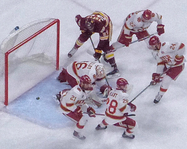  UMD’s Riley Tufte battled for position at the Denver net with Pioneers Michael Davies (21), Logan O’Connor (22), Colin Staub (24) and Adam Plant (28) -- and goalie Tanner Jaillet. Photo credit: John Gilbert
