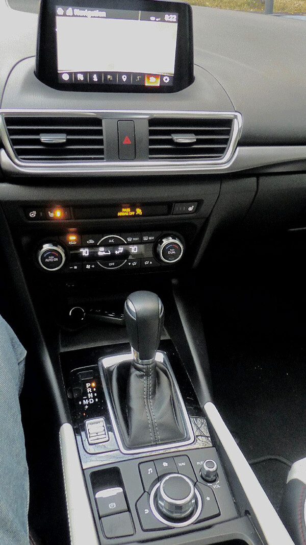 The center pod is simple, and the console houses the shifter and a sport-mode  control. Photo credit: John Gilbert