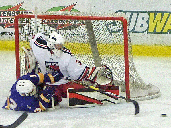 East goaltender Brody Rabold made the save, but couldn’t prevent Cloquet’s Gavin Rasmussen from winding up in the net. Photo credit: John Gilbert