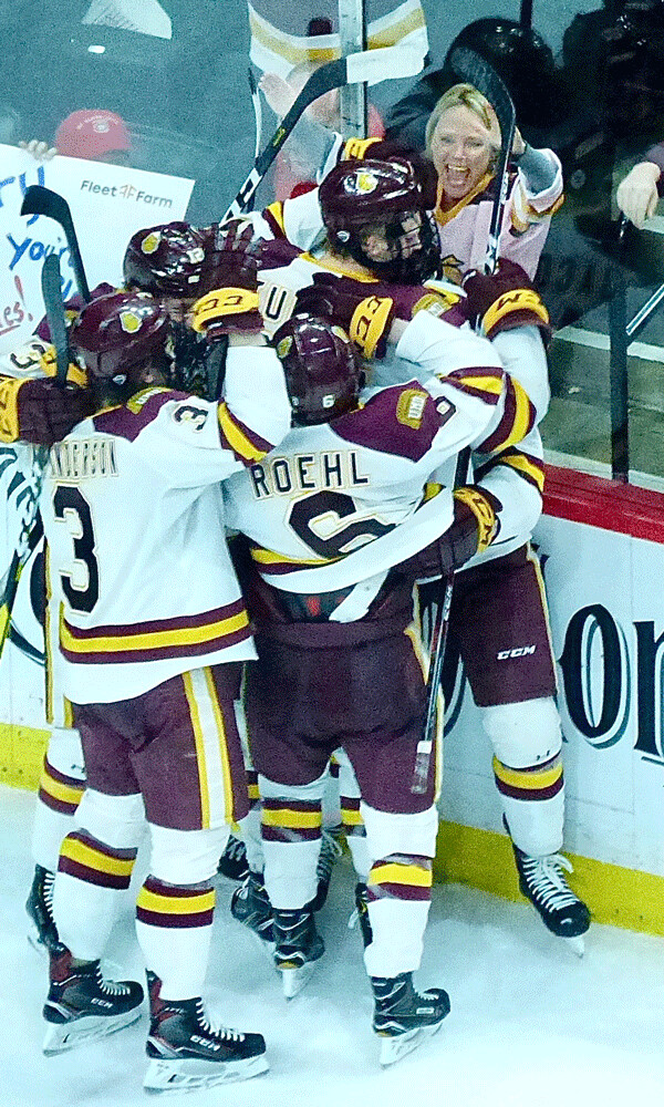 The UMD Bulldogs have made it a familiar sight to follow their playoff games with a giant celebration up against the boards. Photo credit: John Gilbert
