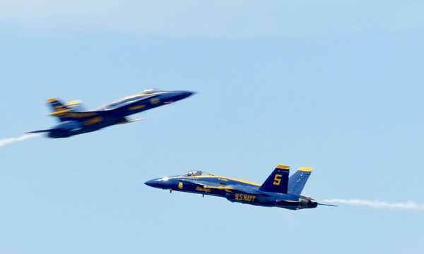As one Blue Angel zooms to the west, a teammate zooms by above him, headed  east. Photo credit: John Gilbert