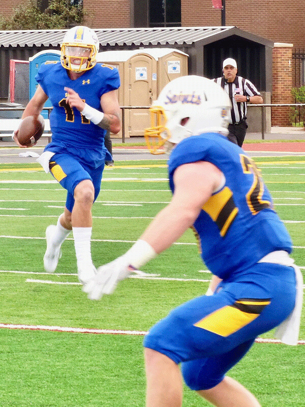 St. Scholastica quarterback Zach Edwards, who threw four touchdown passes and ran for two more, carried around end as Brhceton Butkiewicz looked for someone to block. Photo credit: John Gilbert