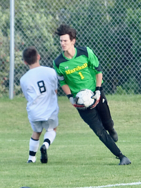  Marshall goalkeeper Charlie Eginton beat East attacker Nolan Haney to the ball and prepared to clear the area. Photo credit: John Gilbert