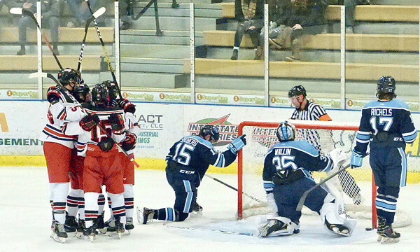 East's team engulfed Garrett Johnson after his goal gave the Greyhounds a 3-1 lead in their 4-1 victory over Blaine at Essentia Heritage Center. Photo credit: John Gilbert