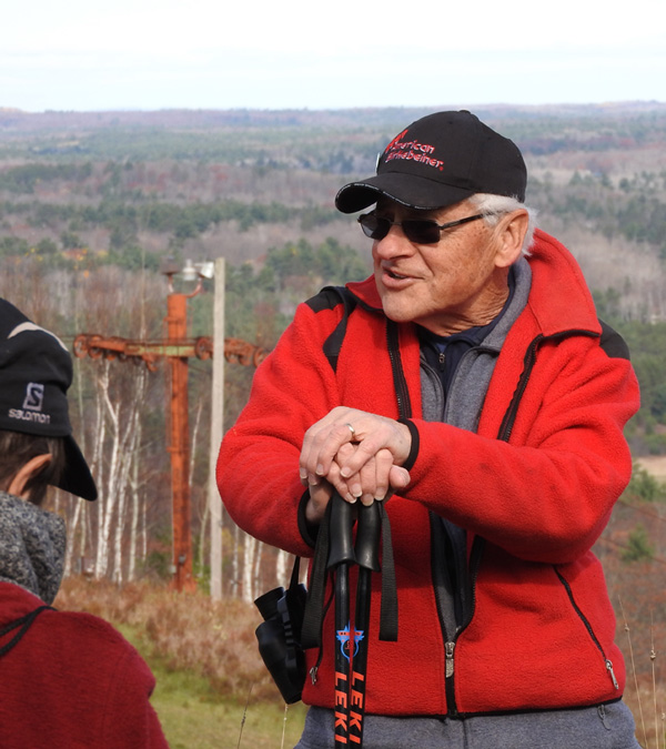 John Kotar talks about the geologic history of Mount Telemark while the rusty tower from a chair lift conveys speaks to events in the hill’s more recent past. Photo by Emily Stone.