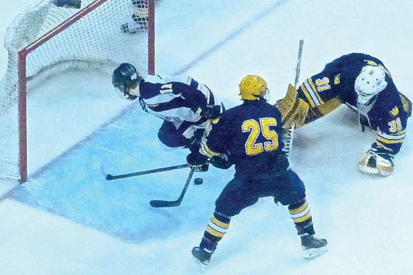 Ryan Sandelin went airborne while letting his own short-handed shot slide into the Breck goal to finish Hermantown's 5-0 championship game. Photo Credit: John Gilbert