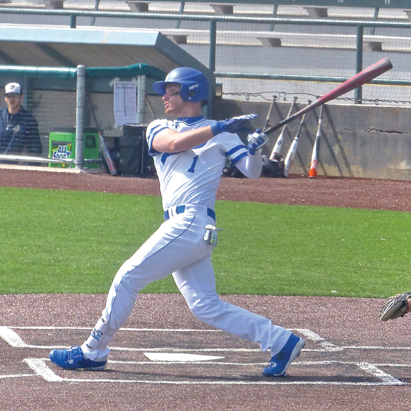 Junior catcher Trevor Bernsdorf drilled a base hit as St. Scholastica whipped North Central 14-1 at Wade Stadium in the Saints home opener. Photo credit: John Gilbert