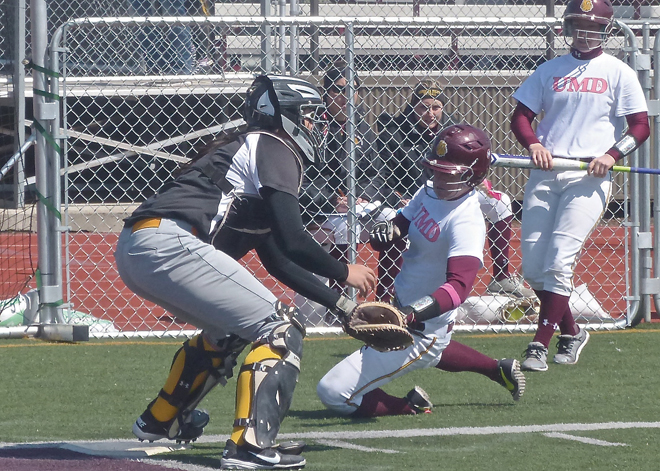 Hannah Schmoll slid home against Minnesota State-Crookston, finding the plate at the intersection of the football turf goal line and sideline. Photo credit: John Gilbert