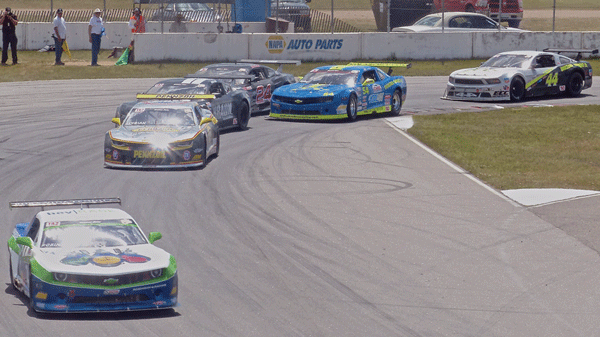 After a late caution, the top six TA2 contenders were bunched, with Gar Robinson leading, followed by Lawrence Loshak, Justin Haley, Dillon Machavern (24), Tommy Archer, and Adam Andretti (44). Photo credit: John Gilbert