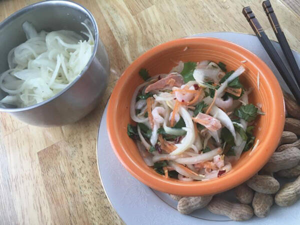 Onion salad with grated carrot, cabbage, ginger and celeriac, and shrimp, salmon, crushed chili flakes and fresh cilantro.”  By Ari LeVaux.