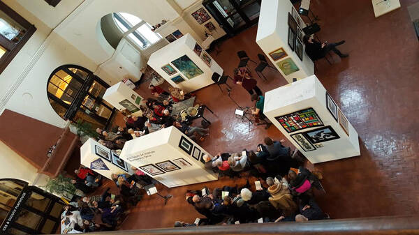 Erin Aldridge and Betsy Husby surrounded by art and audience. Photo credit: Patty Mester