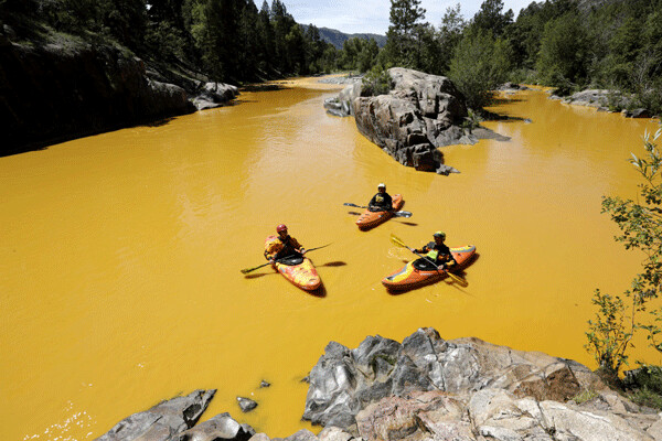 People kayak in the Animas River near Durango, Colo., in water colored from an EPA mine waste spill. (Jerry McBride/The Durango Herald, via AP)