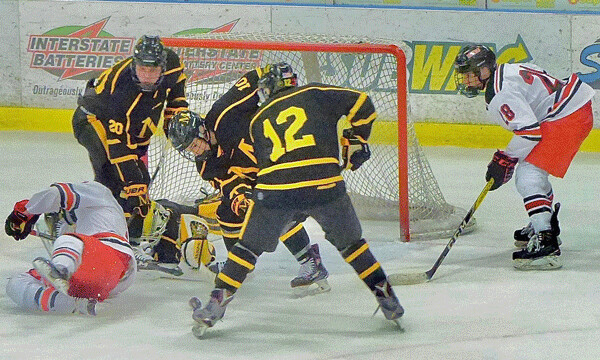 East sophomore Logan Anderson, right, stayed clear of an overtime scramble, and when the puck came loose, he scored for a 3-2 victory over Marshall. Photo credit: John Gilbert