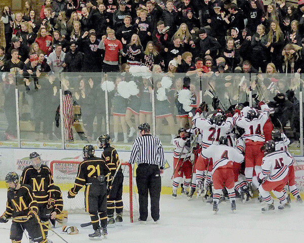 The Greyhounds poured onto the ice and engulfed Logan Anderson, whose second goal of the season came in overtime of the emotional 3-2 victory over Marshall. Photo credit: John Gilbert
