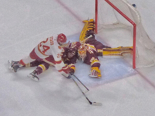  Denver’s Colin Staub gathered in a rebound as UMD goaltender Hunter Shepard dived across the crease, and defenseman Mikey Anderson tried to intervene. Staub scored the eventual game-winning goal to break a 1-1 tie in the second period of their NCHC semifinal. Photo credit: John Gilbert