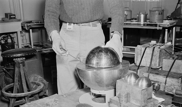 A re-creation of the 1946 experiment. The half-sphere is seen, but the core inside is not. The beryllium hemisphere is held up with a screwdriver. The incidents happened at the  Los Alamos laboratory in 1945 and 1946, and resulted in the acute radiation poisoning and subsequent deaths of scientists Harry Daghlian and Louis Slotin
