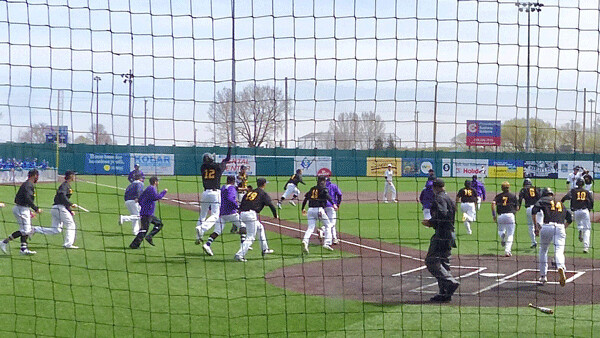 Northwestern College players streamed off the bench after a 5-run ninth toppled UWS 10-9, turning a walk-off UMAC victory into a run-on celebration. Photo credit: John Gilbert