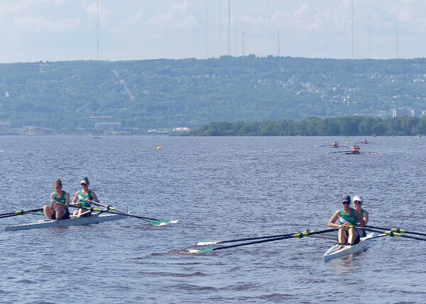 Entries in the Women’s doubles event set off for the north starting point of the sprint race course in the St. Louis Bay. Photo credit: John Gilbert