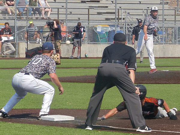 Wearing their customary Sunday military tribute camouflage jerseys, Corbell fired a pickoff throw against Eau Claire. Photo credit: John Gilbert