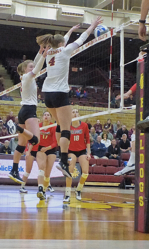 Emily Torve (4) blocks an MSU-Moorhead kill attempt, assisted by Abby Thor in UMD’s  double block. Photo credit: John Gilbert