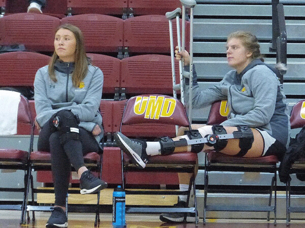 UMD scoring leader Sarah Kelly, left, rested her injured knee, joining Mandy Kurosky, who had  surgery last week for torn knee ligaments, to support the team. Photo credit: John Gilbert