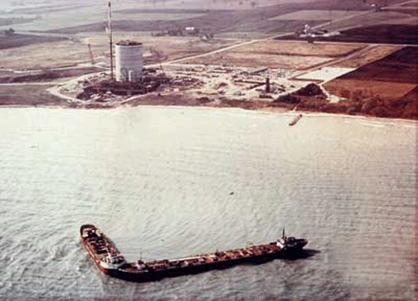 In this photo from the 1970s, barges from KPS Construction help in the construction of the Kewaunee nuclear reactor on Lake Michigan. Federal plans invision the use of barges like these to move hundreds of tons of highly radioactive waste fuel rods from the now closed Kewaunee reactor to the port of Milwaukee. Photo by Power Engineering online.