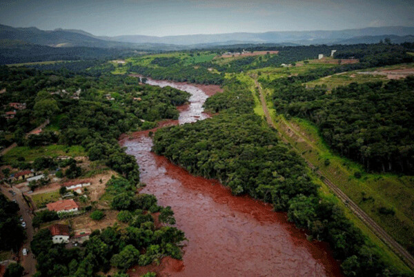 Contaminated river in Brazil, 2015 (presumably the Rio Doce) - note the large number of uprooted trees from the upstream tailings dam breach. This level of pollution kills most if not all fish.