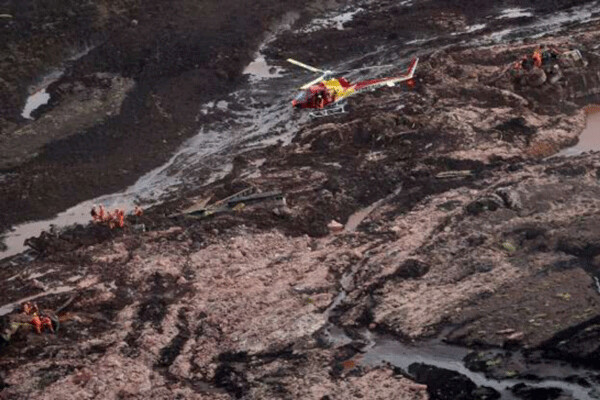 Searching for bodies downstream from the mine tailings pond breach