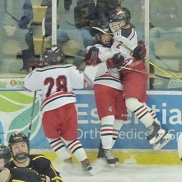 Ricky Lyle was fired up enough to spark Duluth East by scoring the first goal against Marshall, earning celebrations from teammates, including the leaping EJ Hietala and Logan Anderson (28). Photo credit: John Gilbert