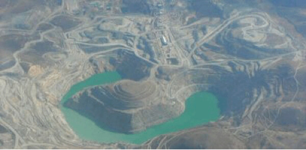 An aerial view of one of Glencore’s abandoned copper mines that is half-full of highly toxic, highly acidic water that will kill any water bird that lands on it.
