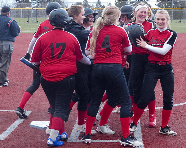 East ninth-grader Cathy Bergstrom was smothered by teammates after her 3-run home run tied  Denfeld 6-6. Both teams had their leads, but Denfeld finally won 15-13. Photo credit: John Gilbert