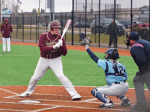 Dane Dzuck, first baseman for Denfeld’s JV team, takes a pitch in a cold, windy makeup game at Superior Tuesday. Photo credit: John Gilbert