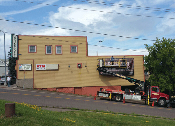 A billboard goes up on the former 4th Street Market building to promote the  Indigenous Foods Expo. (Photo by Richard Thomas)