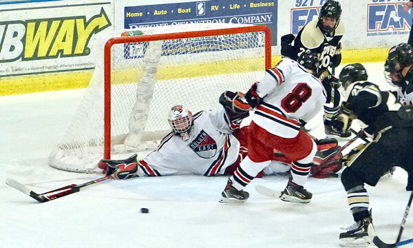 East's "senior rookie" goaltender Karson Kausch sprawled for a save against powerful Andover Saturday at Essential Heritage Center. Photo credit: John Gilbert