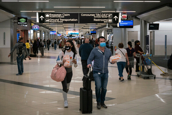 Travelers at Hartsfield-Jackson Atlanta International Airport wearing facemasks in early March 2020 as the Coronavirus spreads throughout the United States. Credit: Chad Davis, FlickrCC.