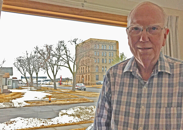 Retiring Douglas County Board Supervisor Doug Finn can see Superior’s old city hall, where he began his career as an elected offi cial 50 years ago, from his living room window. Photo credit Jim Lundstrom.