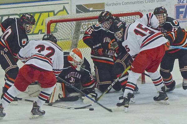 East sophomores Ryder Donovan (22) and Ricky Lyle (15) tried to control a loose puck. Photo credit: John Gilbert