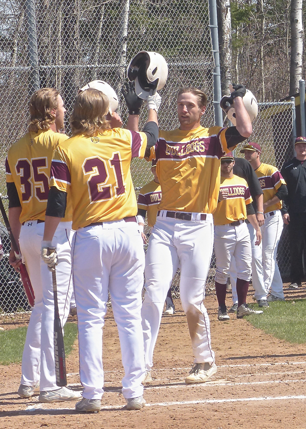 Another UMD home run, another celebration at home plate as Alex Wojciechowski high-fiver senior third baseman Kyle Comer in the 21-6 romp over Minot State. Photo credit: John Gilbert